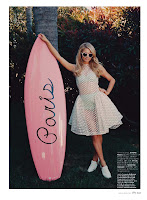 Paris Hilton posing by her pink surf board