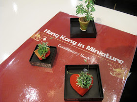Three dolls' house miniature plants, arranged on the guest book for the exhibition Hong Kong in Miniature.