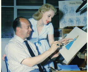 Marc Davis showing a young lady a dress concept for Sleeping Beauty