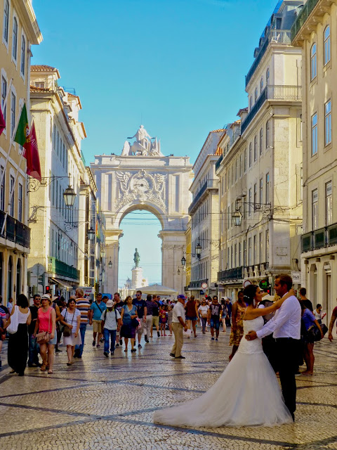 Pareja de novios en la Rua Augusta con el Arco al fondo