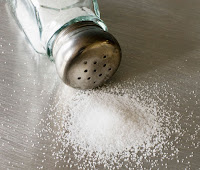 Salt shaker spilling onto table