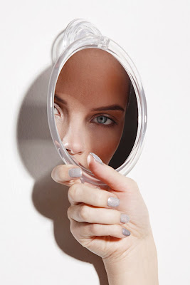 woman looking into mirror