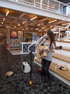 A lady singing for a living at "V & A Waterfront" mall.