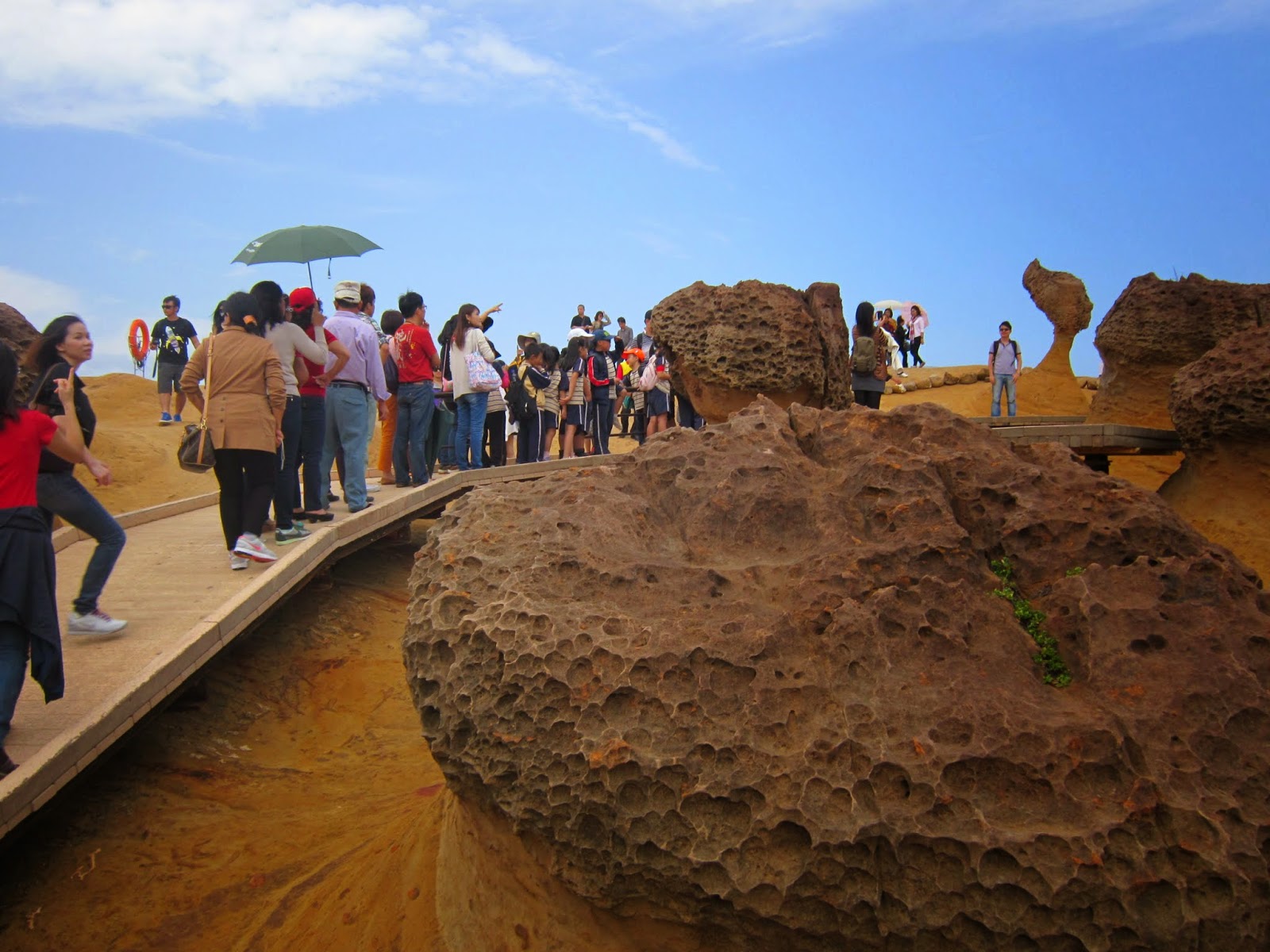 Visitors queue for pictures in front of the famous Queen's Head at Yehliu Geopark at New Taipei City in Taiwan Visitors queue for pictures in front of the famous Queen's Head at Yehliu Geopark at New Taipei City in Taiwan