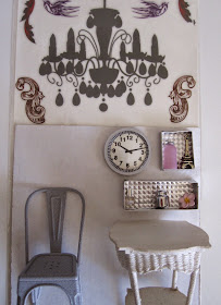 Selection of silver and white dolls house miniature furniture and accessories displayed under a rub-on chandelier sticker in its packet.