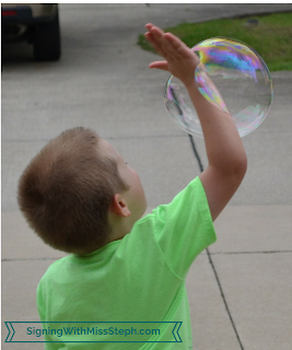 boy popping bubble with arm