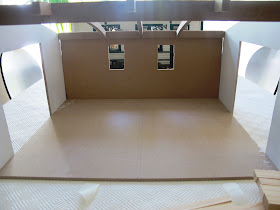 A half-built dolls' house shed from the front.