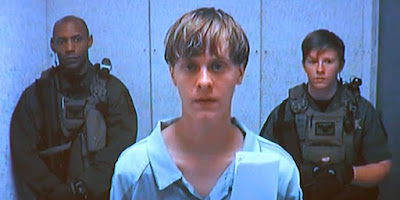 Dylann Roof appeared in court in a video feed from a nearby jail.