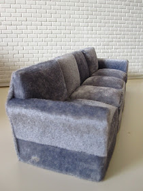 Modern miniature four seater grey velvet sofa.