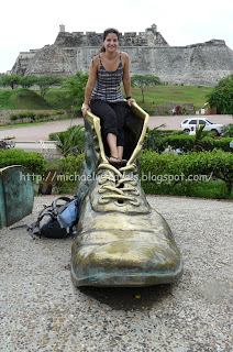 a woman sitting on a statue of a shoe