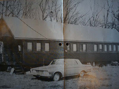 A hunting lodge with car parked in front.