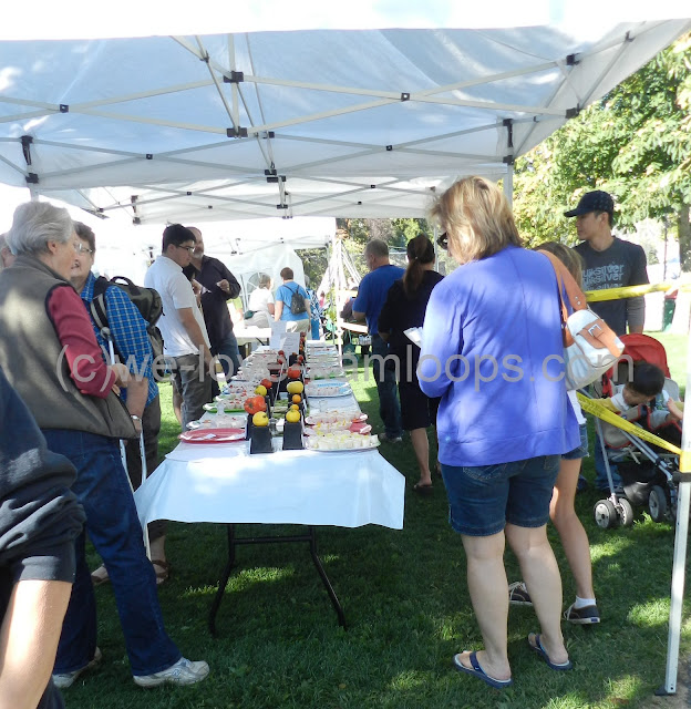 several people line up to do the taste test of tomatoes