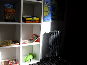 Sun shining on a bookcase in a modern dolls' house miniature pop-up Little Library, 