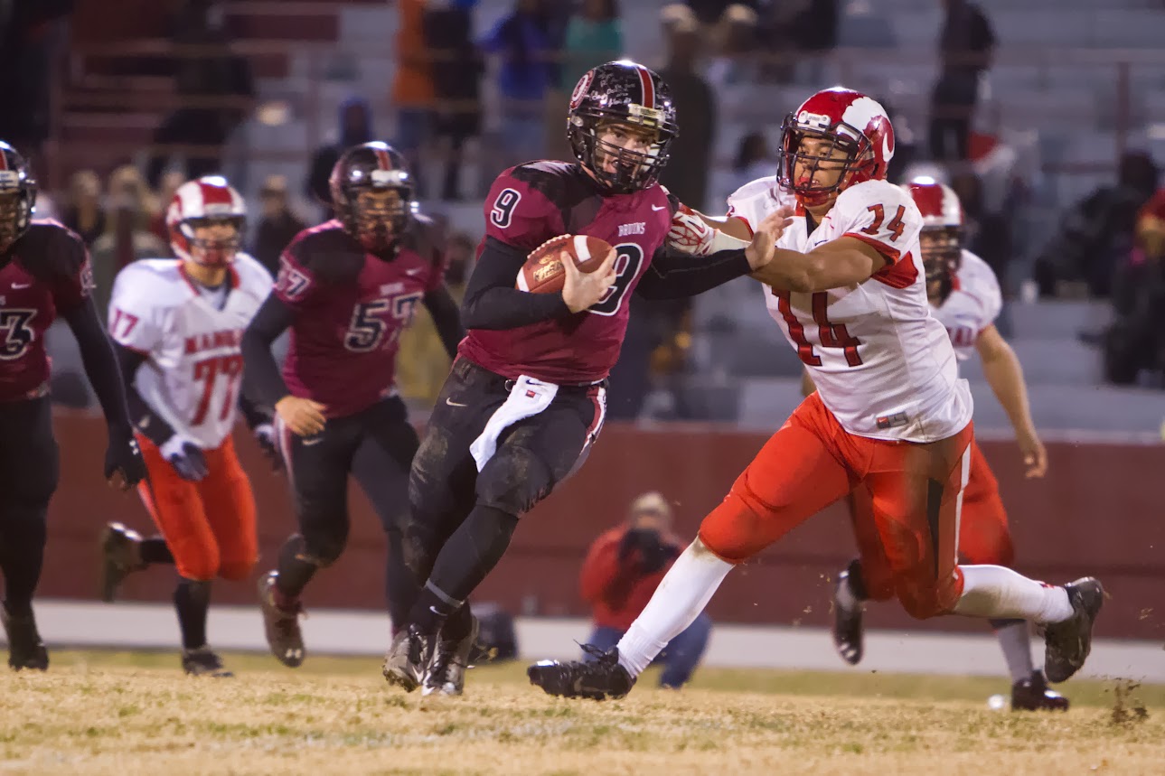 Ballard Quarterback, Rex Wallace, evades a tack from Damien Sm ith, 14, of the Dupont Manual Crimsons. November 8, 2013.(Matt Herp/Special to the ...