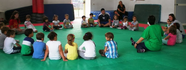 i bambini, in cerchio, durante i giochi in palestra