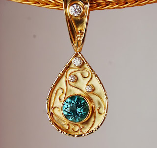 Tear drop shaped pendant with blue stone and diamonds