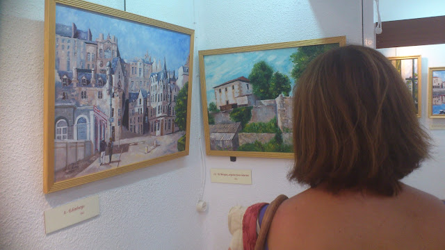 Una mujer mira las pinturas de Arturo de la Fuente
