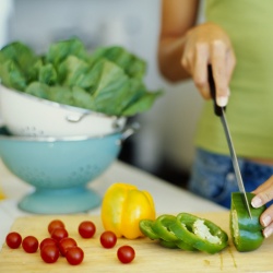 mains qui découpent des légumes avec un couteau, dans une cuisine