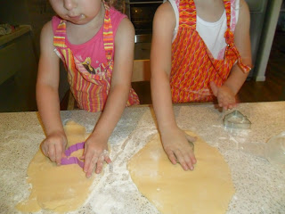 Rolling biscuit dough out on a floured surface.