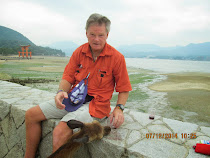 Predatory deer (no wine is safe!) at Miyajima Islan.  O-torii gate of Itsukushima Shrine behind