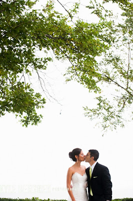 The Bride and Groom kissing under a tree