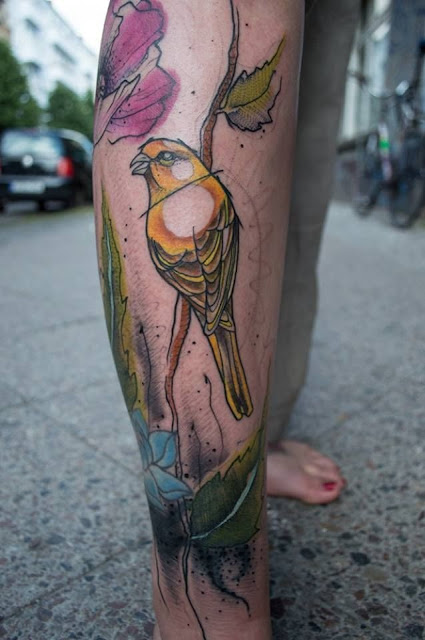 Kolorowy tatuaż ptaka na nodze w stylu graficznym
