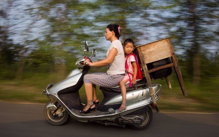 Five-year-old Lu Siling rides with her desk on the back of her mother's motorbike on the first day of school in Macheng, China. There are 5,000 pupils at the schools in the town, but only about 2,000 desks. So more than 3,000 children have to go to school with desks and chairs, like their parents' generation. Some children even use their parents' old desks.Picture: China Foto Press / Barcroft Media