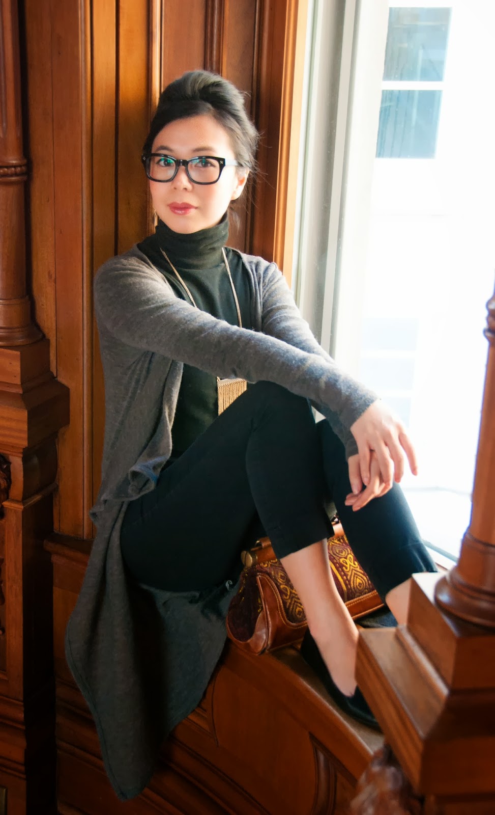 grey cardigan black turtleneck trousers pants statement necklace geek-chic glasses bouffant loafers