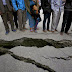 People gather near the cracks caused by an earthquake in Nepal