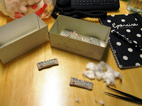 Office desk with unstuffed dolls house miniature cushions, cotton balls and tweezers.