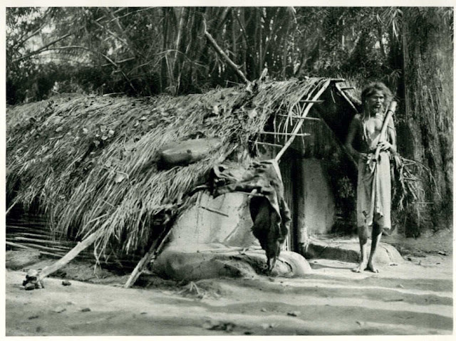 Kadu+Tribesman+in+front+of+a+Hut+near+Mysore,+Karnataka+-+India+1928
