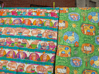 A fabric printed with pigs, and one with farm animals 
