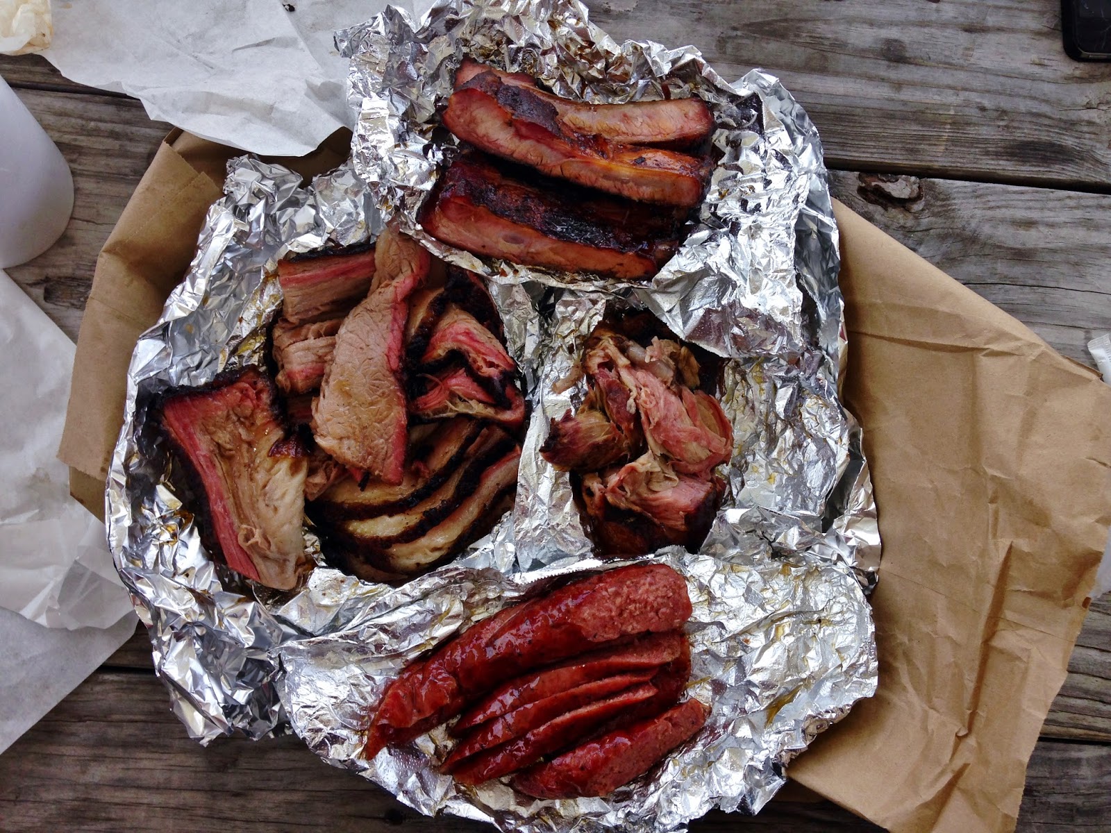 Spread of four of Brooks' meats: Brisket, Pulled Pork, Pork Ribs, Sausage