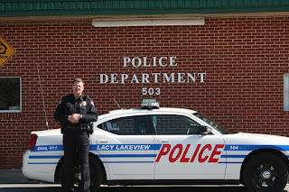 Chief Stapleton in front of a Lacy Lakeview Police car.