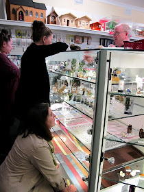 Customers browsing the displays of dolls' house miniatures at Fairy Meadow Miniatures.