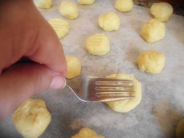 slightly flatten each ball of cookie dough with a fork