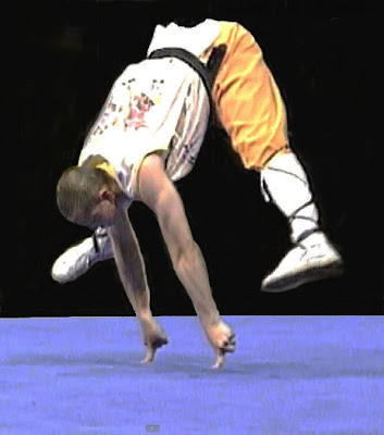 Tanar Shaolin facand o demonstratie de forta, sprijinindu-se in doua degete si ridicandu-se in aer