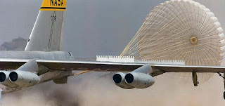 Space shuttle drag chute deploys in a cloud of dust behind NASA's NB-52B research aircraft