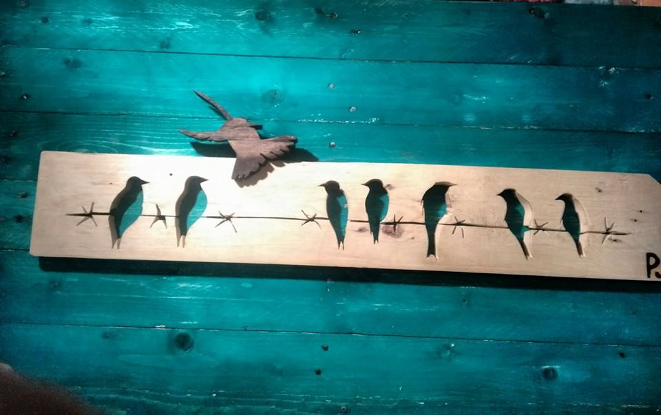 Siluetas de pájaros posados en alambre de espino