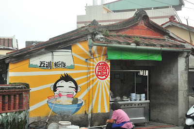 2011.3本站工作人員替社區特色商店進行牆面彩繪，引來聚落保存區內是否洽當的質疑。