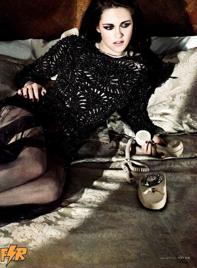 Kristen Stewart on the bed with a phone in her hand