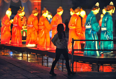 Visitors walk beside colorful lanterns ahead of the Seoul Lantern Festival at the Cheonggye stream in central Seoul on October 31, 2013. The festival is part of a campaign by South Korea to attract more foreign tourists and runs from November 1 to 17