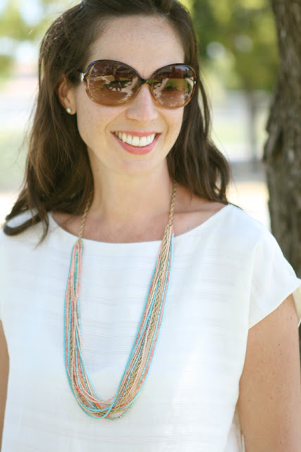 Andrea wearing a white t-shirt, sunglasses and the mulit-strand seed bead necklace