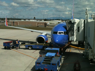 a blue airplane being loaded onto a white plane
