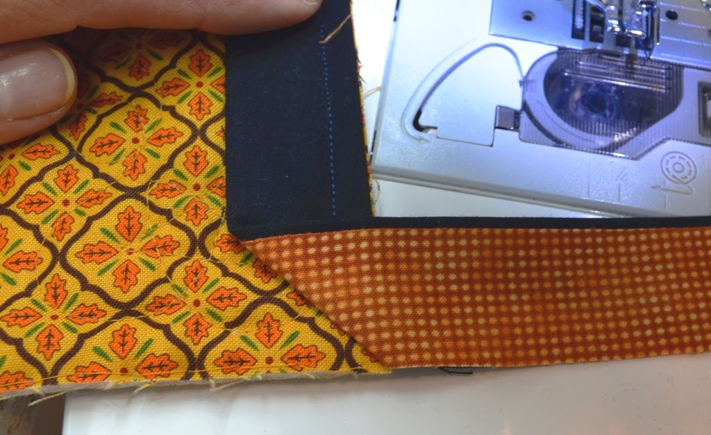 Fold binding back down, keeping the folded edge evenly aligned with the previous corner, and