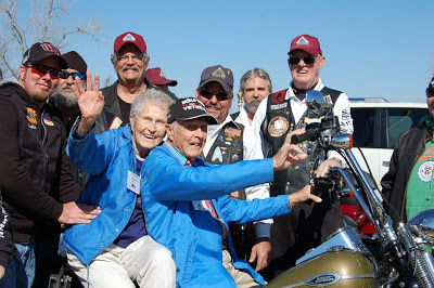 WWII Veteran and wife sit on a motorcycle