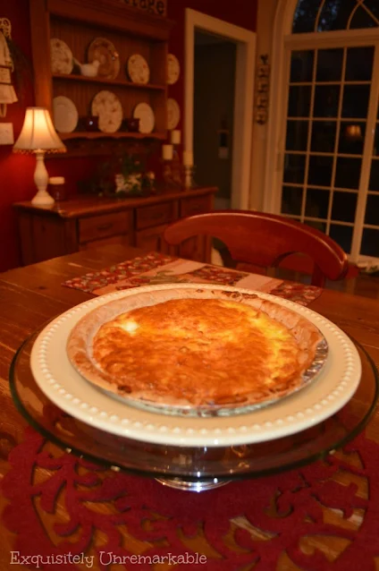 Quiche on a glass plate rack in a red kitchen