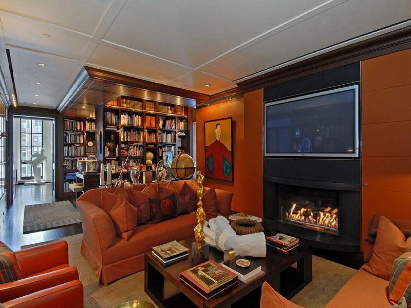Photo of sitting area in the private library with brown sofas and fireplace
