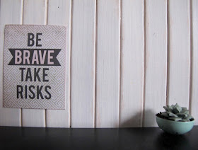 A modern dolls' house miniature scenewith a poster saying 'Be brave take risks, and a succulent in a bowl. 
