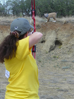 A Women’s Wilderness Escape participant aims her arrow at a plastic bobcat.